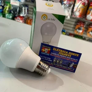 Foto com uma caixa de lâmpada Led de fundo e outra exposta na frente de 20 Watts, branco frio, 6500k da marca Luz Sollar