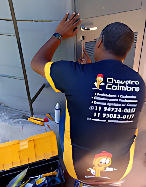 Chaveiro fazendo a manutenção da chave de uma porta comercial.
