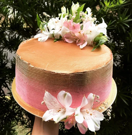 Bolo Gold e rosa com detalhes de flores enfeitando