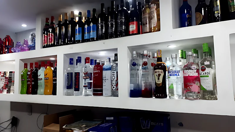 Estante com várias garrafas de bebidas alcoólicas e vinhos